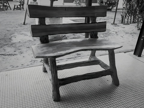 View of a stone chair for the use of visitors. Black and white picture.