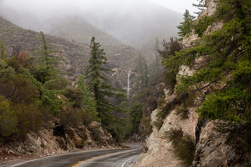 A long and winding road snaking through the fog-covered mountainside