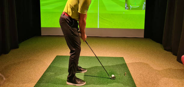 istock Male golfer plays golf indoors on golf simulator 1498564314