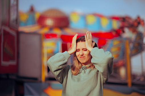 Fearful girl feeling dizzy and panicked at funfair