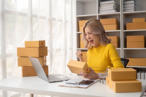 Portrait of Starting small businesses SME owners female entrepreneurs working on receipt box and check online orders to prepare to pack the boxes, sell to customers, SME business ideas online.