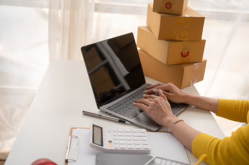 Portrait of Starting small businesses SME owners female entrepreneurs working on receipt box and check online orders to prepare to pack the boxes, sell to customers, SME business ideas online.