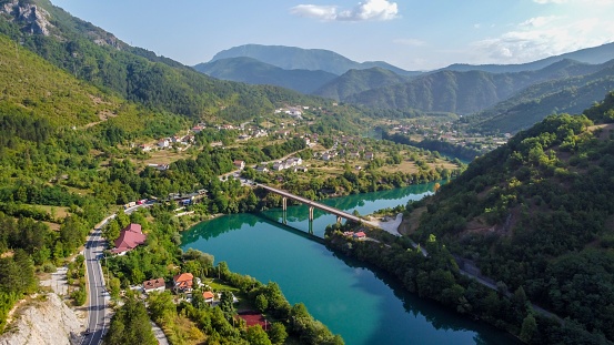A scenic view of a road passing through a majestic gorge, with a bridge in the distance in Bosnia