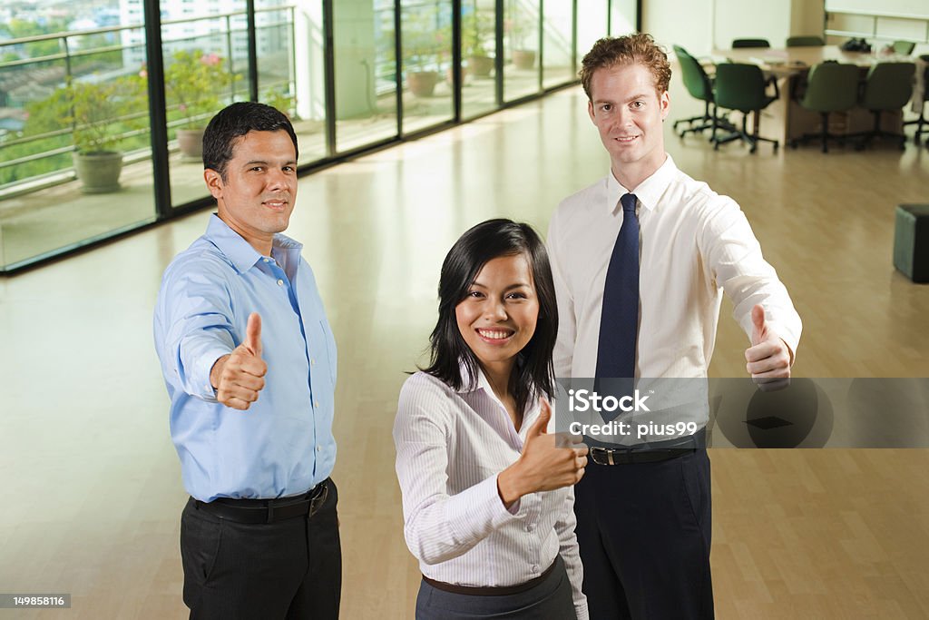 Equipe diversificada de negócios com três polegares para cima - Foto de stock de Escritório royalty-free