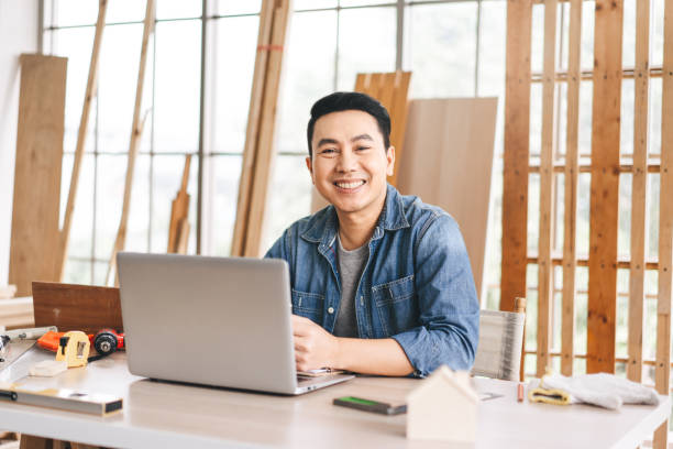 porträt mittleren alters erwachsener südostasiatischer mann schreinerjob bei der arbeit zu hause - southeast asian ethnicity men laptop image type stock-fotos und bilder