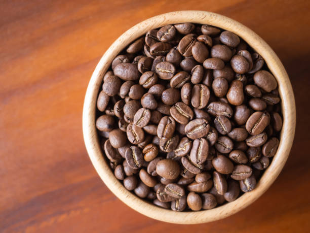 istock brown arabica coffee bean roast level medium taste delicate lively bright seed caffeine espresso drink food cafe beverage Chiang Rai, Thailand coffee on wooden table background top view selected focus 1498584461