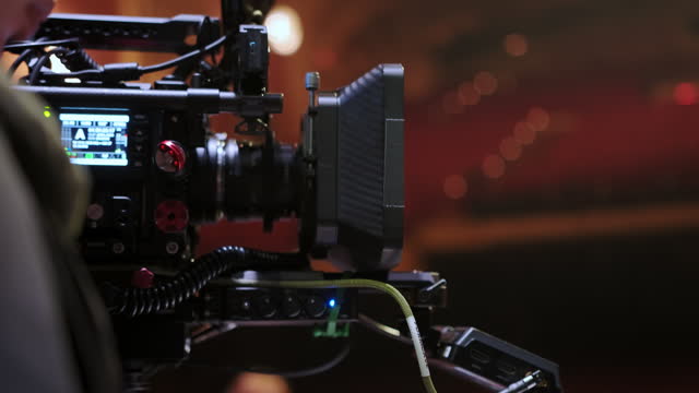 Close up of Professional digital cinema camera with set of light hanging in studio background. move camera footage