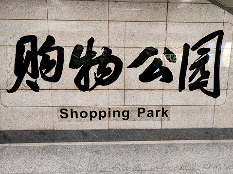 Sign on wall at Shopping park mtr station, a popular shopping and nightlife area in Futian central business district, Shenzhen, a large modern city in Guangdong province, China