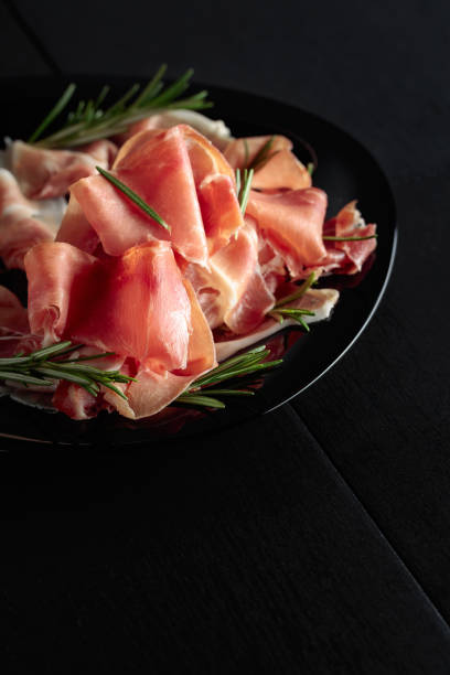 istock Italian prosciutto or Spanish jamon with rosemary. 1498598933