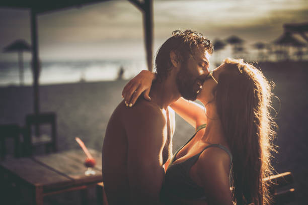 istock Young affectionate couple kissing on the beach. 1498604297