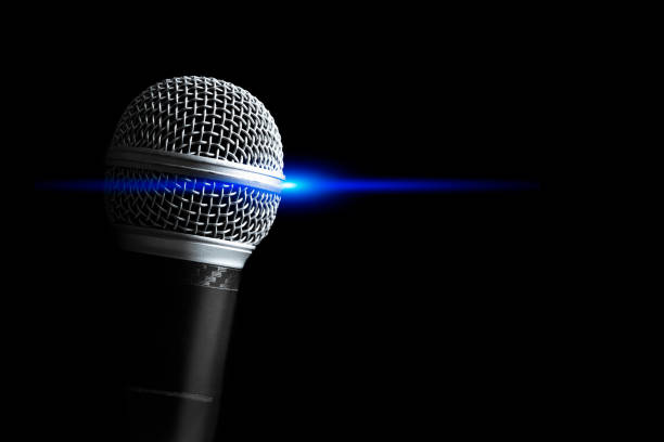 istock Close up dynamic microphone with blue concert light, isolated on black. Singing, recording, broadcasting, speech concept 1498604404