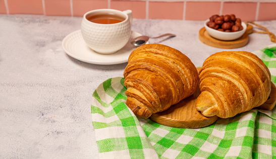 Croissants lie on a wooden board lies on the table.