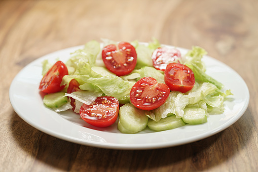 vegetable salad with tomato, cucumber and iceberg lettuce, closeup photo