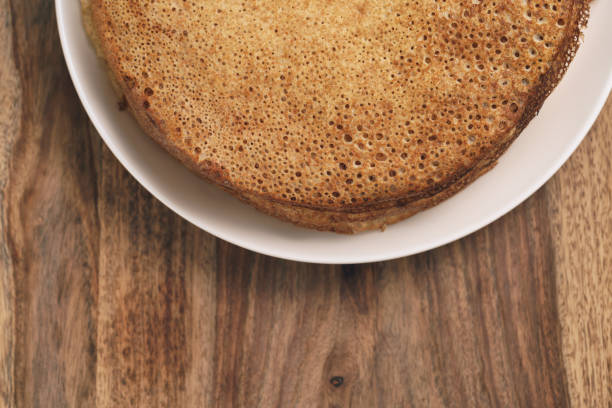 homemade crepes on plate on wood table, shallow focus