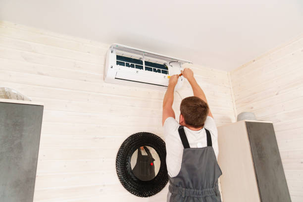 istock A man unscrews an air conditioner on the wall with a screwdriver 1498608020