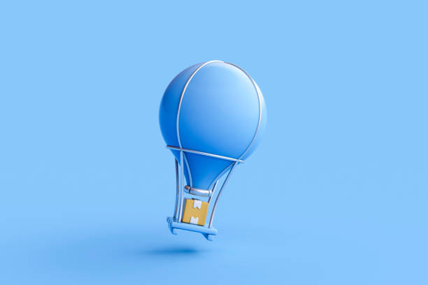 A blue helium balloon with a yellow ribbon floats up into a cloudy blue sky.