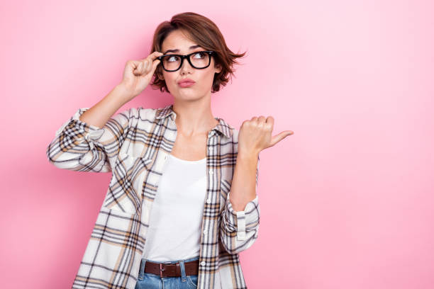 istock Photo of young student girl intern worker pointing finger empty space pouted lips choosing salary offer isolated on pink color background 1498616445