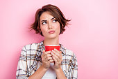Photo of funny young lady coffee break looking empty space thoughts about her favorite tasty cup tea isolated on pink color background