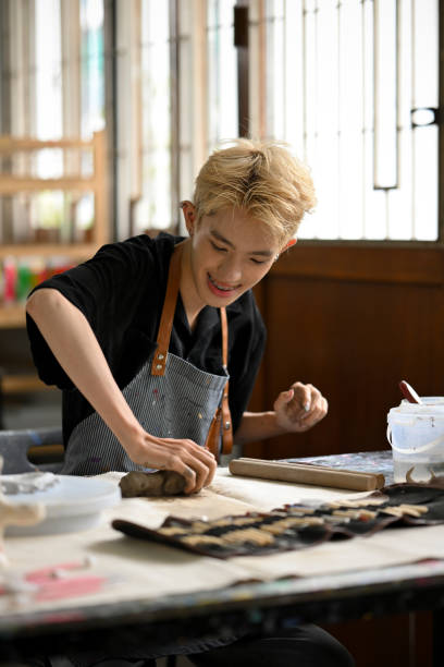 istock A happy man enjoys making earthenware or sculpting an ornament with raw clay 1498618600