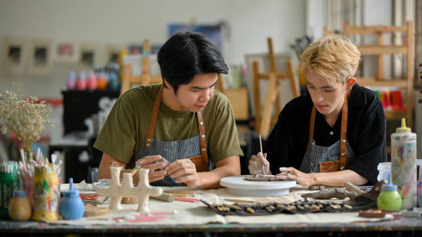 istock Two young Asian men join in a handicraft workshop and enjoy making clay ornaments 1498618853