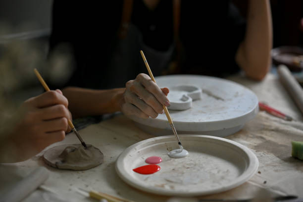istock Close-up image of a man enjoying painting a ceramic plate in a creative handicraft workshop 1498619688
