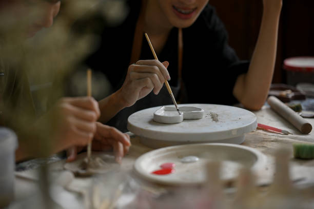 istock Close-up image of a man enjoys painting a ceramic plate in a creative handicraft workshop 1498619811