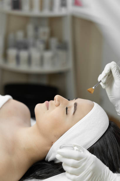 revela los secretos de un peeling facial efectivo en esta foto, que muestra el cuidado y rejuvenecimiento de la piel en un salón profesional. sensación de relajación y frescura en una mujer durante el procedimiento - mujeres-de-banners-verticales fotografías e imágenes de stock