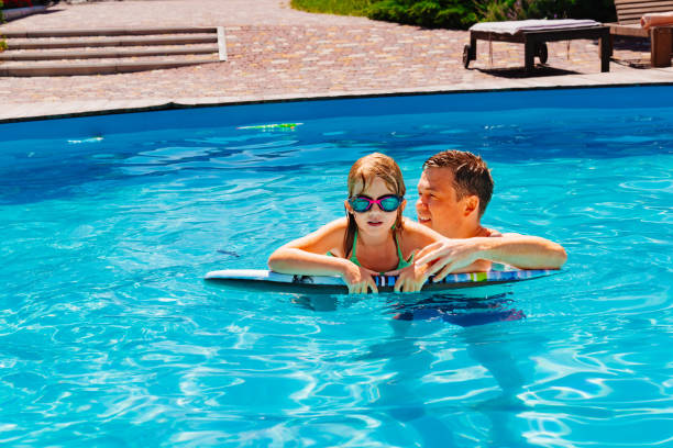 istock Dad and daughter have fun and swim in the pool. 1498620657