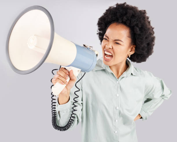 istock Megaphone, protest and black woman shouting in studio isolated on white background. Screaming, angry and person with loudspeaker protesting for human rights, change or justice, announcement or speech 1498621375