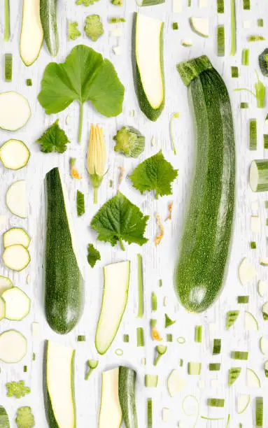 Zucchini vegetable piece, slice and leaf collection. Flat lay, seamless abstract on wooden background.