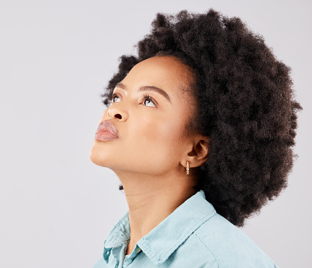 Black woman, afro and thinking in studio with vision, ideas or looking up by white background. Girl, young model and student with idea, brainstorming or mindset for focus, fashion or calm by backdrop