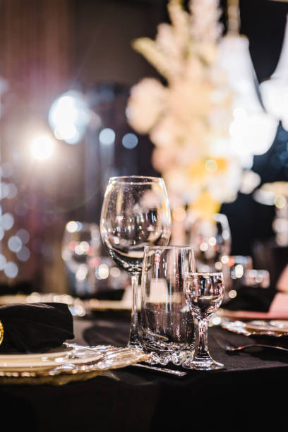 istock Serving, setting table. Plate and glass, stack, wineglass, luxury golden rich decor. Side view. Closeup. Wedding set up, dinner table reception. Birthday, baptism, event. Closeup details interior. 1498624307