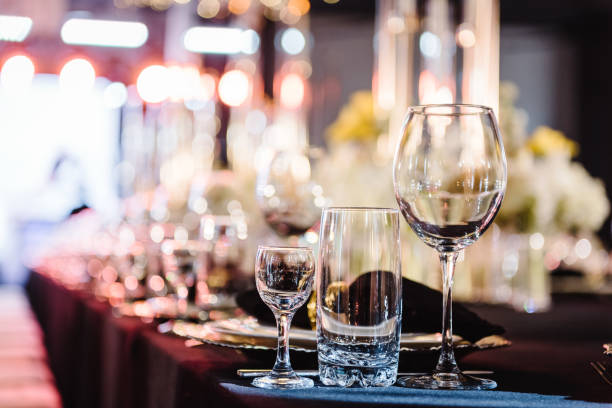 istock Serving, setting table. Plate and glass, stack, wineglass, luxury golden rich decor. Side view. Closeup. Wedding set up, dinner table reception. Birthday, baptism, event. Closeup details interior. 1498624309