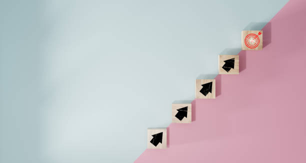 istock Virtual target board and arrow which print screen to wooden cube block on blue and pink background. Business achievement goal and objective target concept. 1498625317