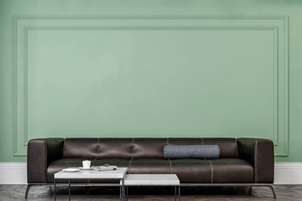 istock Cozy retro-chic interior with a black leather cushion sofa, paneled wall with moldings, 50s- 60s decoration 1498625810