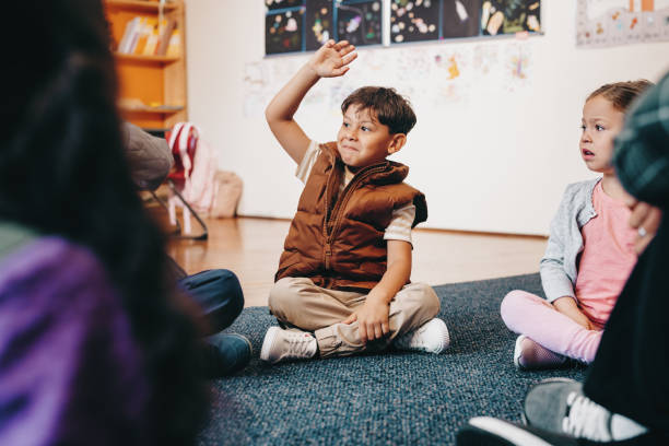 istock Smart elementary school kid raises his hand to give an answer in class 1498627428