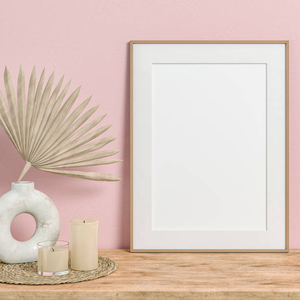 Simple interior with a cabinet and a large rectangle picture frame and the 50s- 60s decoration (candles on a place mat) Simple interior with a large rectangle picture frame with passe-par-tout, leaning on a hardwood cabinet in front of a baby pink wall background and copy space. A low ceramic vase with different dried plants (palm leaves, dry flowers), and candles on a rattan placemat. The 50s- 60s decoration, art Deco style. A slight vintage effect was added. 3D rendered image. art deco vase stock pictures, royalty-free photos & images