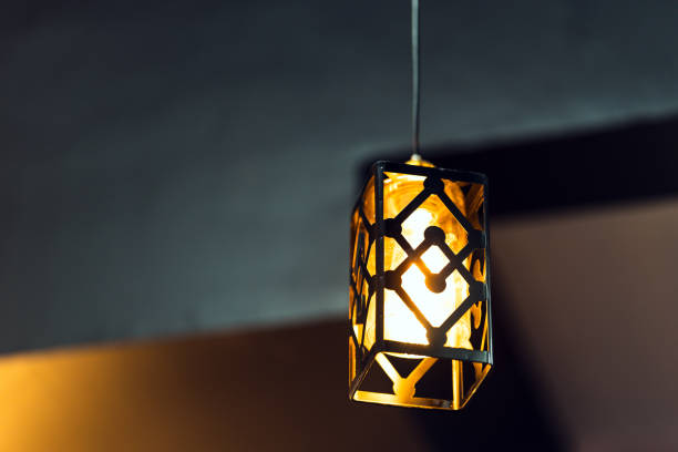 istock A lamp with a rectangular iron frame suspended from the ceiling, illuminating in gold. Interior concept. 1498629161