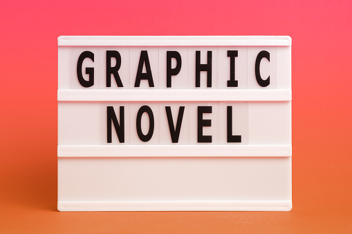 The word graphic novel on lightbox isolated pink background. Literary Genres