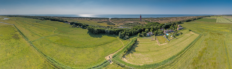 Drone panorama of Ouddorp lighthouse in Holland with surrounding dunes during daytime in summer