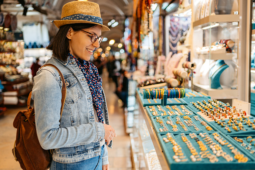 Beautiful young woman looking at jewelry at the Grand Bazaar In Kapali Carsi in Istanbul, Turkey.