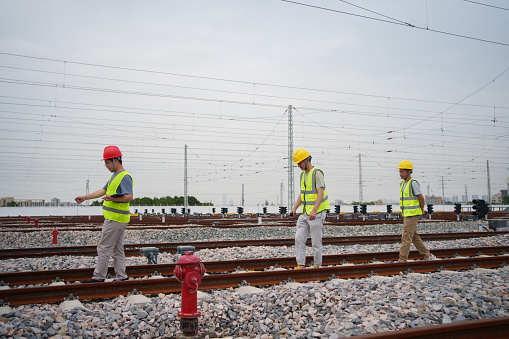 Three railway workers inspecting the tracks