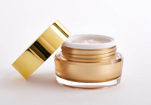istock golden color cosmetic jar with open cap containing moisturizing cream, isolated on white background 1498633654
