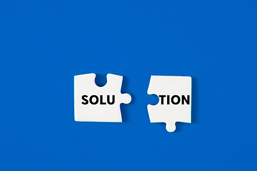 Two puzzle pieces connected each other to create solution word