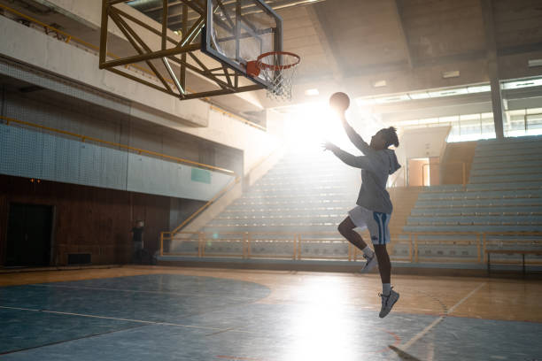 Man playing basketball Basketball player throwing ball in hoop on sports court during practice. making a basket scoring stock pictures, royalty-free photos & images