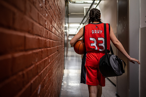 Young female with a basketball in an outdoor court