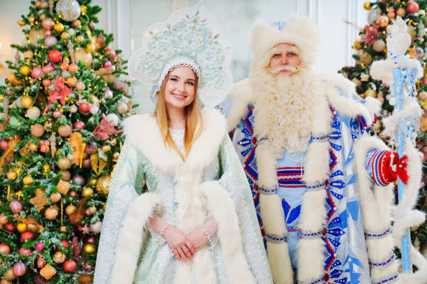 дед мороз и снегурочка в голубых костюмах в комнате с елками - snow maiden стоковые фото и изображения