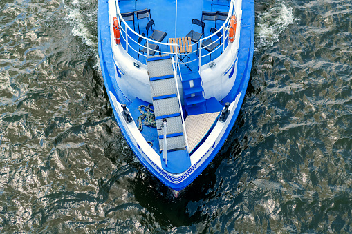 Top view: a small blue ship floating on the river