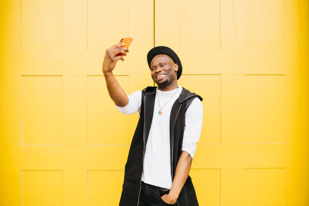 istock Young man taking a selfie with yellow background 1498640736