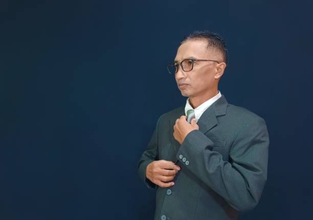 istock Isolated image of businessman is fixing his tie. 1498641982